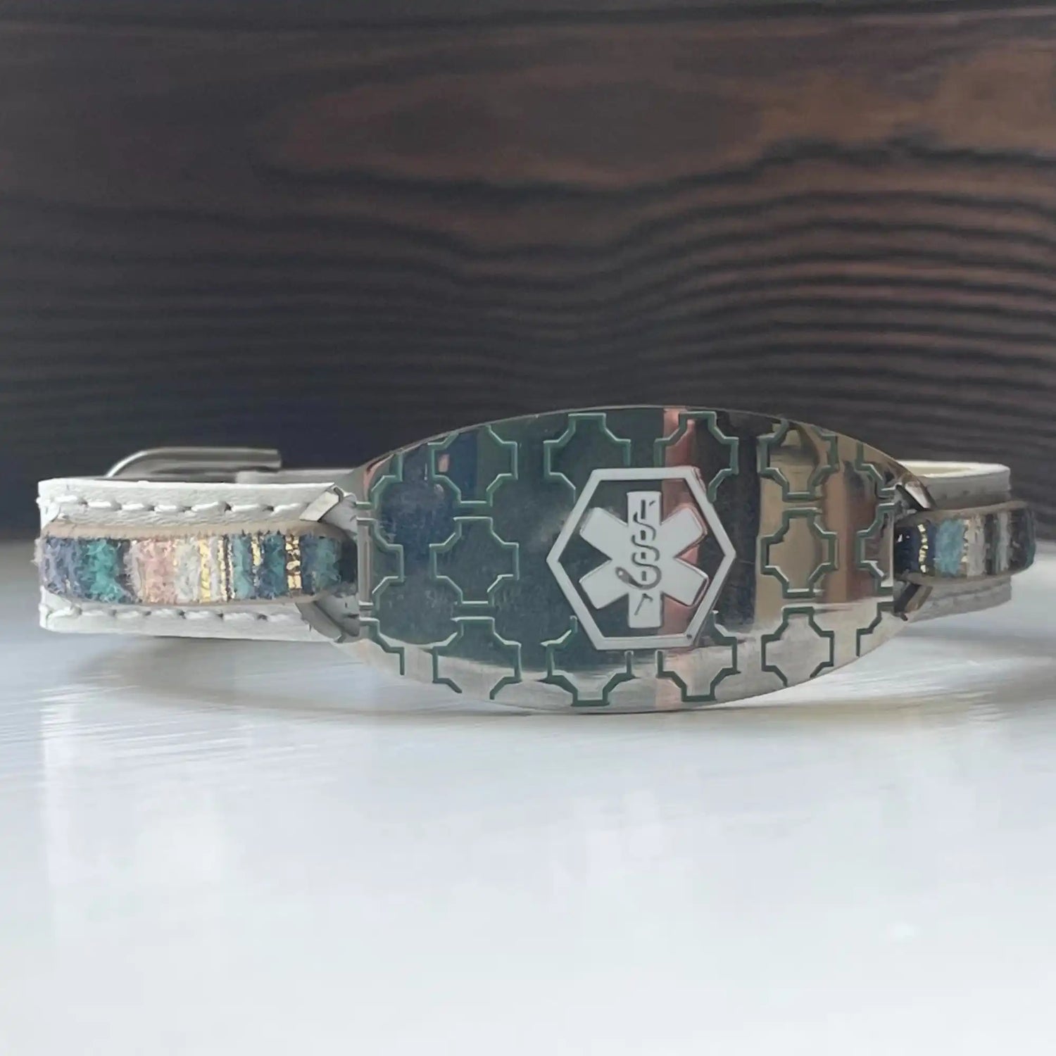 White leather medical alert bracelet with a silver-toned, patterned ID plate and colorful bead accents.